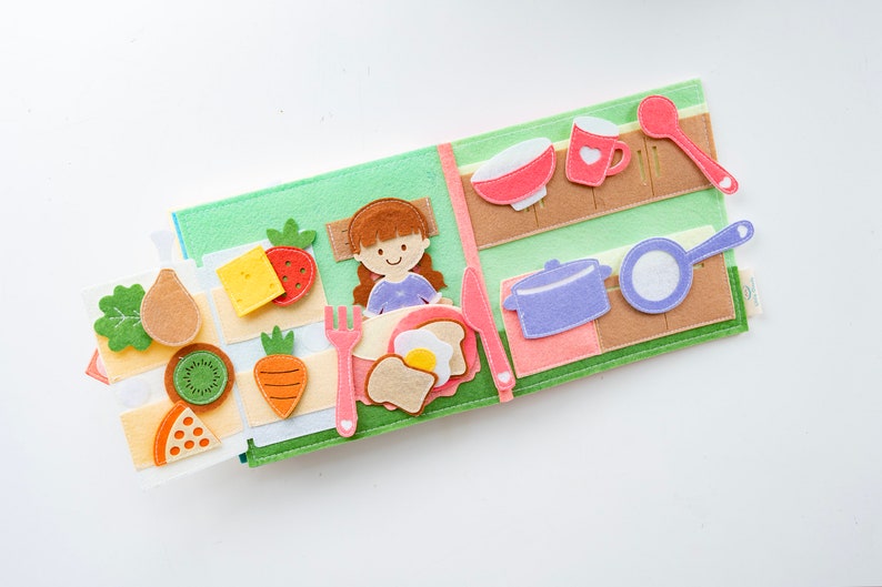 dollhouse quiet book page 5 and 6 square shaped, felt material, light and soft, about baby breakfast with a lot food on table and refrigerator is open with full of full as potato, kiwi, cheese, carrot, strawberry. pastel color