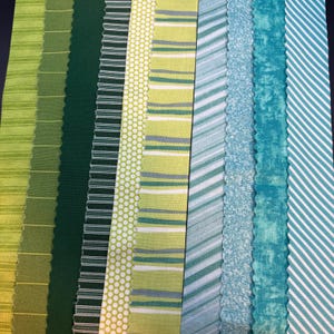 May include: A collection of ten vertical fabric strips arranged side-by-side, featuring a variety of patterns including thin horizontal lines, solid dark green, white polka dots on lime, horizontal stripes, diagonal stripes, and mottled teal.