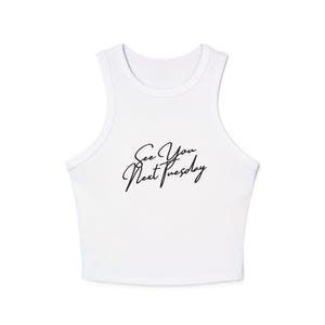 Op de afbeelding: Witte crop top met een racerback design. De top heeft de tekst "See You Next Tuesday" in zwarte cursieve letters op de voorkant. De top is gemaakt van een zacht, lichtgewicht materiaal.