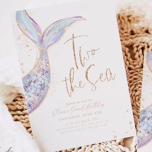 May include: A mermaid tail with purple, blue, and gold glitter accents on a white background. The text "Two the Sea" is written in gold glitter. The text "Splash on over for Olivia's Second Birthday" is written in pink. The text "Saturday, June 4th 4 O'Clock PM 123 Anywhere St. Any City, AP RSVP to Sam at 355-955-3593" is written in black.