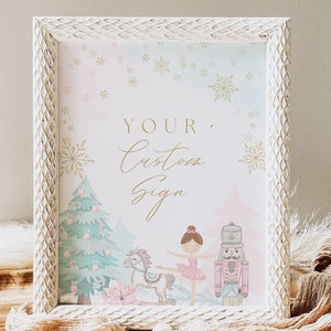 May include: A white frame with a custom sign inside. The sign features a watercolor illustration of a ballerina, a nutcracker, a rocking horse, and a Christmas tree. The text on the sign reads "Your Custom Sign".