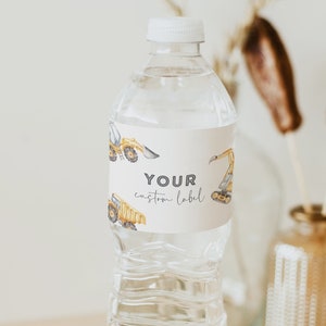 May include: A clear plastic water bottle with a white cap and a label that says "YOUR custom label". The label has a pattern of yellow construction vehicles. The bottle is sitting on a wooden coaster.