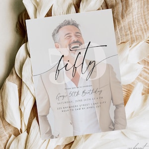 May include: A white invitation card with a black and white photo of a man smiling. The card has black text that says "Please join us to celebrate Greg's 50th Birthday" and includes details about the event, such as the date, time, and location. The card also has a black cursive font that says "fifty" on the top left corner.