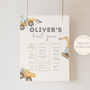 May include: A printable first year milestone chart for a baby boy. The chart features a yellow construction truck theme with illustrations of trucks and excavators. The chart includes the baby's name, Oliver, and details about their first year, including weight, height, favourite foods, and first words.