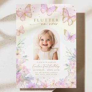 Peut inclure: Une invitation de premier anniversaire rose et or avec un motif floral aquarelle et des papillons. L'invitation présente une photo d'une jeune fille et le texte "Flutter on over" et "Emilia's First Birthday".