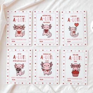 Puede incluir: Juego de seis tarjetas de San Valentín con ilustraciones de ajolotes. Cada tarjeta presenta un diseño de ajolote diferente con frases como "You make me smile A-LOTL" y "Happy Valentine's Day!" Las tarjetas tienen un fondo blanco con bordes de corazones rojos.