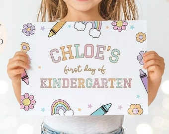 May include: A white printable sign with a rainbow, stars, and crayons. The sign says "CHLOE'S first day of KINDERGARTEN".