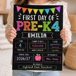 May include: A black chalkboard sign for the first day of Pre-K with colourful text and bunting. It features the name Emilia, age 4, career goal teacher, hobbies gymnastics, drawing, and dog, school year 2026/27, teacher Mrs. Jones, and Highland Park Preschool.