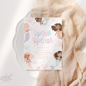 Op de afbeelding: Een uitnodigingskaart met zeemeermint thema met de tekst "Splish Splash" in pastelkleuren. De kaart bevat illustraties van zeemeerminnen en de tekst "Olivia's 5th Birthday". De kaart ligt op een wit bord met een perzikkleurige stof.