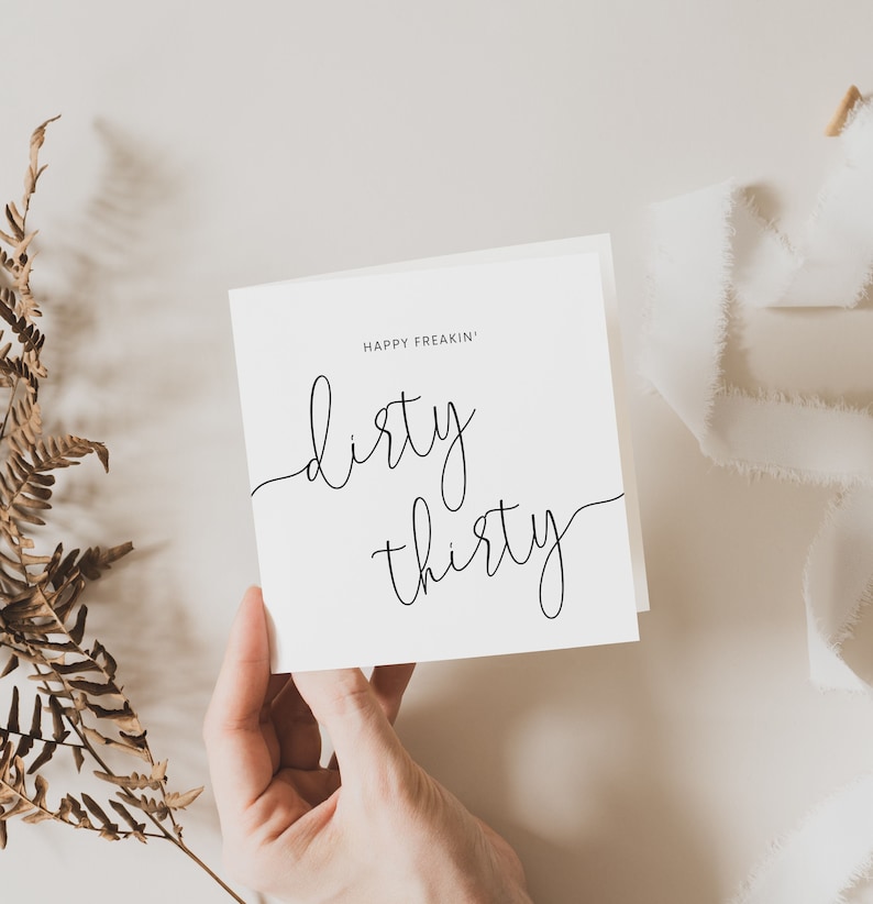 May include: A white card with black calligraphy that reads "Happy Freakin' Dirty Thirty".