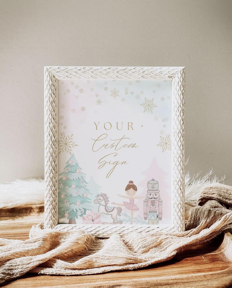 May include: A white framed sign with the text "YOUR Custom Sign" in gold script. The sign features illustrations of a Christmas tree, a ballerina, a toy horse, and a nutcracker. The frame has a textured, diamond pattern.