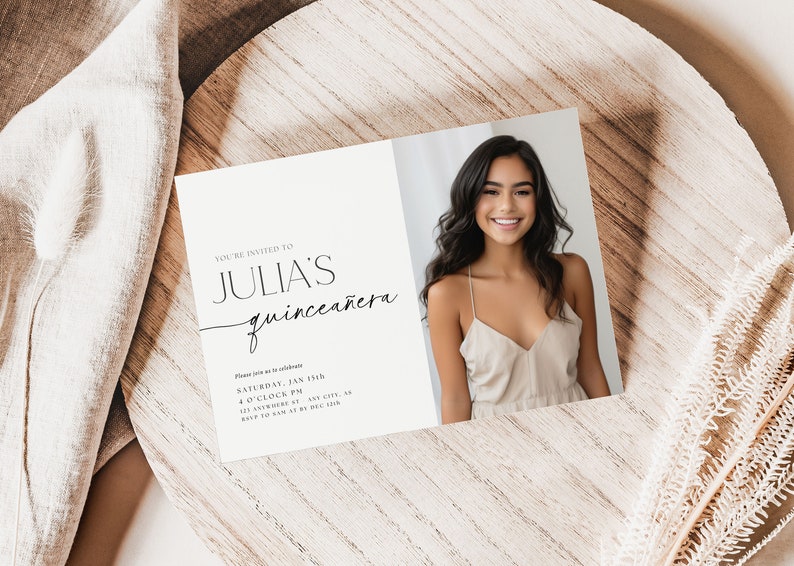 K&ouml;nnte beinhalten: Eine gefaltete Einladungskarte mit dem Text "YOU'RE INVITED TO JULIA'S quincea&ntilde;era" in schwarzer Schrift. Die rechte Seite zeigt eine l&auml;chelnde junge Frau in einem beigen Kleid. Die Karte liegt auf einer Holzoberfl&auml;che.