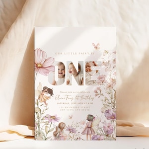 Może przedstawiać: Zaproszenie urodzinowe z motywem wr&oacute;żki z napisem "OUR LITTLE FAIRY IS ONE". Zawiera zdjęcie dziecka, ilustracje wr&oacute;żek i szczeg&oacute;ły wydarzenia. Projekt zawiera r&oacute;żowe i fioletowe kwiaty.