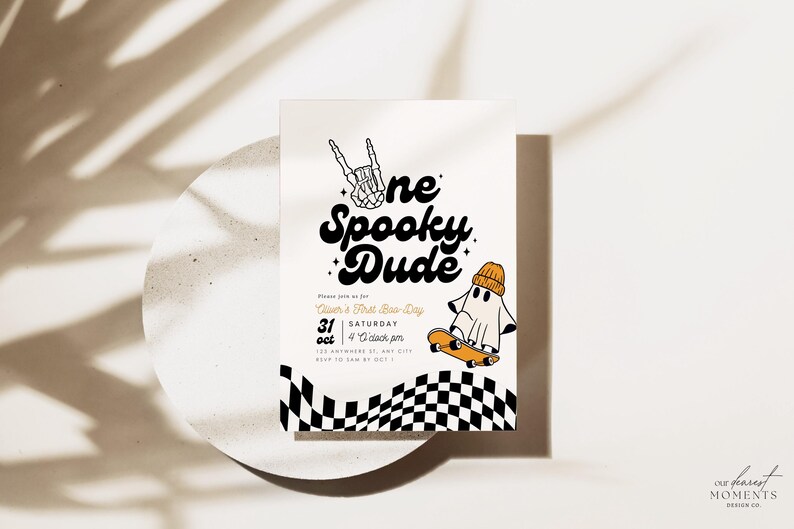 May include: A white invitation card with black and orange text that reads "One Spooky Dude", a ghost wearing a beanie riding a skateboard, and a black and white checkered pattern. The text also includes "Join us for [Name]'s First Birthday", "Saturday, October 31st", and "4 o'clock pm".