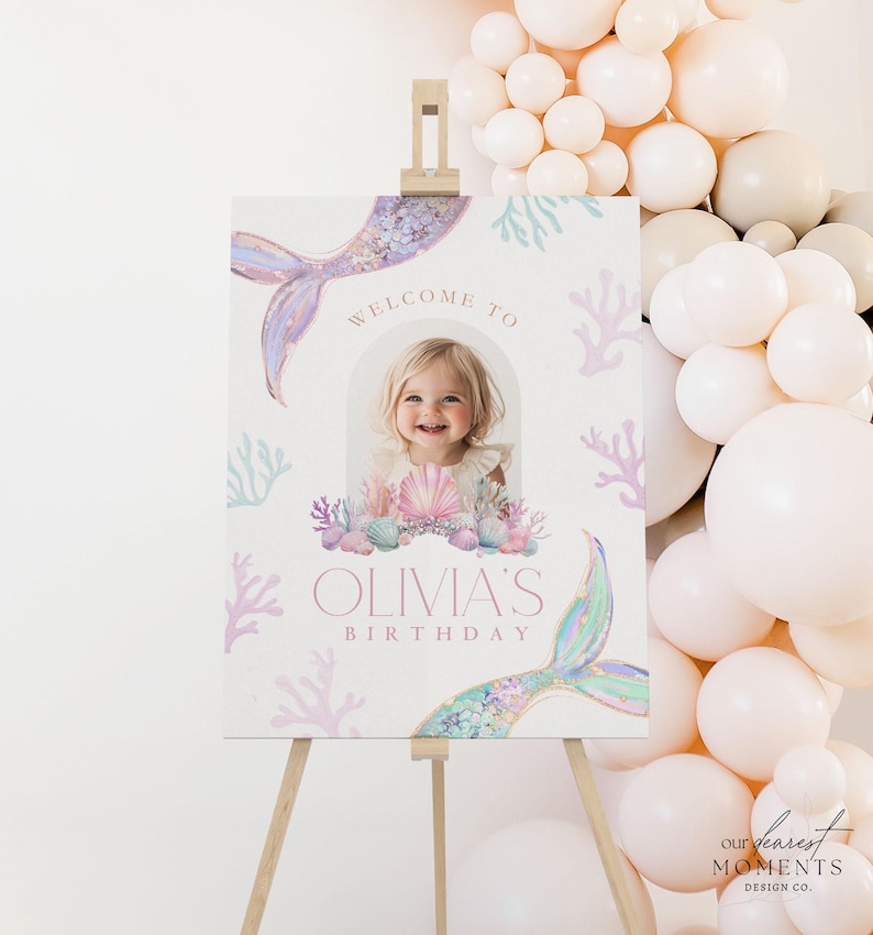 May include: A welcome sign for a birthday party with a mermaid tail, seashells, and coral. The sign says "Welcome to Olivia's Birthday".