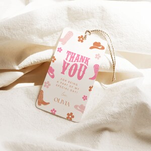 May include: A white thank you tag with pink and orange cowboy boot and hat illustrations. The text reads "Thank You" in pink letters with a pink and orange floral pattern. The text below reads "For being a part of my special day! Love, Olivia."