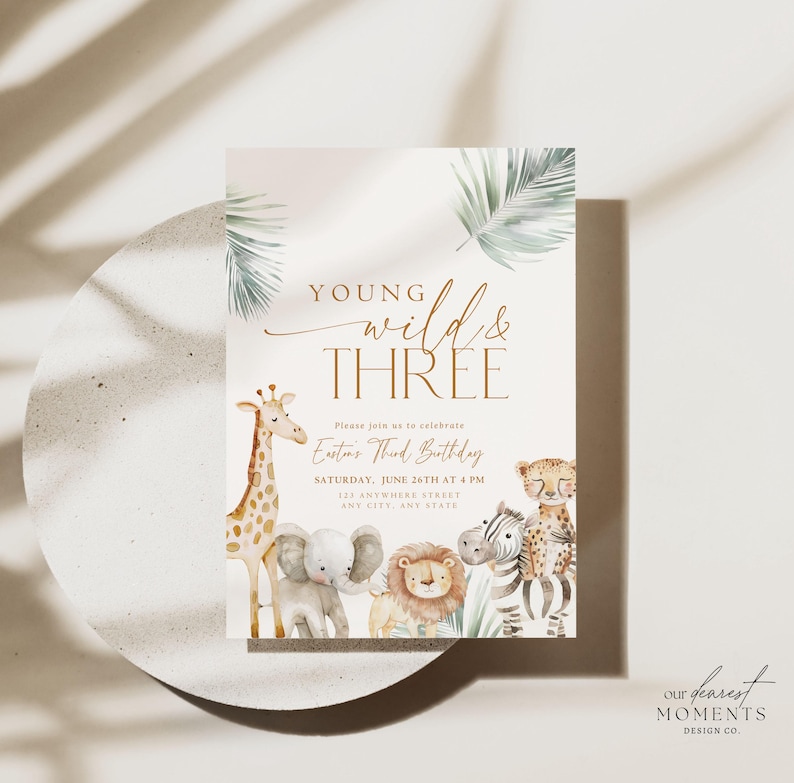 May include: A light pink invitation with a jungle theme. The invitation says "Young Wild & Three" and features a giraffe, elephant, zebra, and lion. The text says "Please join us to celebrate Easton's Third Birthday, Saturday, June 26th at 4 PM, 123 Anywhere Street, Any City, State."