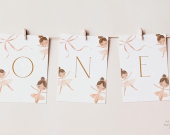 May include: A banner spelling "ONE" is strung across a neutral background. Each card features a ballerina illustration in a tutu and a bow. The letters are in a gold color. The banner is held by wooden clips.