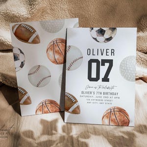 May include: Two rectangular birthday invitation cards featuring watercolour illustrations of a football, basketball, baseball, soccer ball, and golf ball. The right card displays the text OLIVER 07, Join us to celebrate, OLIVER'S 7TH BIRTHDAY, SATURDAY, JUNE 2ND AT 4PM, 125 ANYWHERE STREET, ANY CITY, ANY STATE.