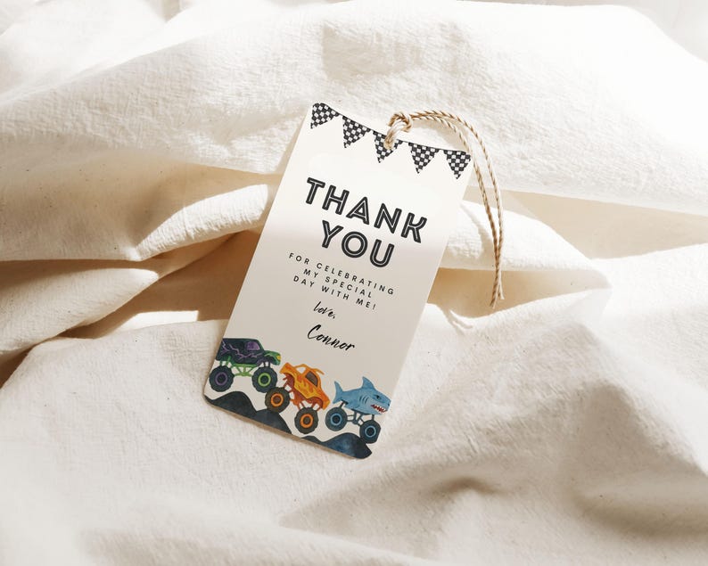 May include: A white gift tag with the words "THANK YOU" in bold black letters. Below the text are the words "FOR CELEBRATING MY SPECIAL DAY WITH ME! Love, Conner." The bottom of the tag features illustrations of monster trucks. A string is attached to the top.