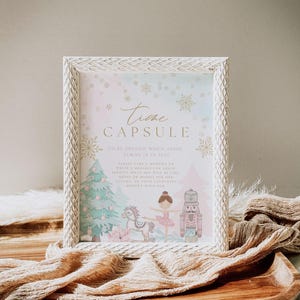 May include: A framed print with the words "Time Capsule" and decorative snowflakes. The print features a Christmas tree, a ballerina, a toy horse, and a nutcracker. The text reads "To be opened when Addie turns 18 in 2043."