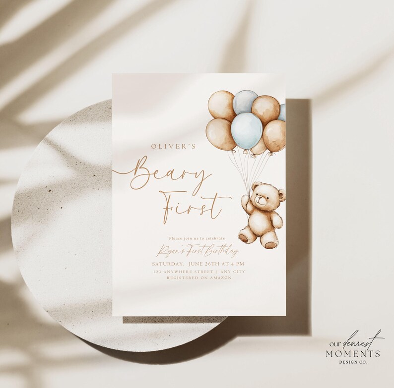 May include: A light brown teddy bear holding onto blue and brown balloons. The invitation reads "Oliver's Beary First" and includes the text "Please join us to celebrate Ryan's First Birthday, Saturday, June 24th at 4 PM, 123 Anywhere Street, Any City, Registered on Amazon".