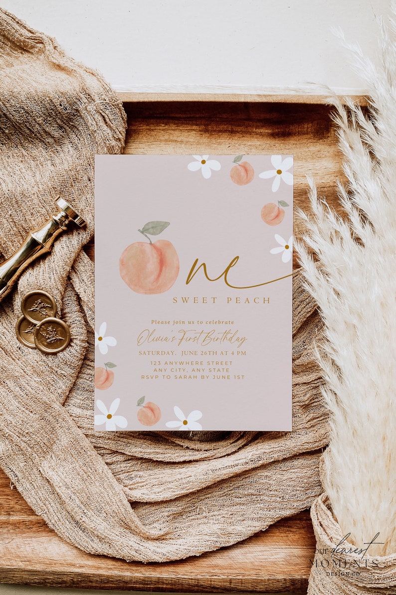 Może przedstawiać: R&oacute;żowa karta zaproszenia z akwarelowym wzorem brzoskwini i kwiat&oacute;w. Tekst brzmi "Sweet Peach" i zapowiada przyjęcie z okazji pierwszych urodzin. Złote akcenty i rustykalna estetyka.