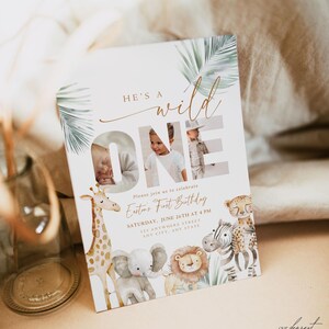 May include: A rectangular invitation card with the text "He's a Wild One" and the word "ONE" in large letters. The card features photos of a baby and illustrations of safari animals, including a giraffe, elephant, and lion.