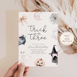 May include: Printable Halloween party invitation with a watercolour design featuring a cauldron, a ghost, a spiderweb, a skeleton, a witch, and a pumpkin. The text on the invitation reads "Trick or Three" and "Oliver's Third Birthday".
