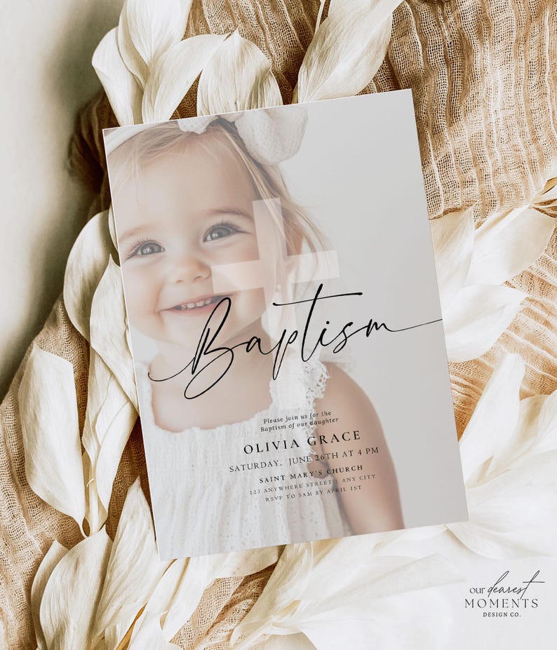 May include: A baptism invitation card featuring a smiling child with a white bow. The card has the word "Baptism" in elegant script, along with event details: Olivia Grace, June 26th at 4 PM, and Saint Mary's Church.