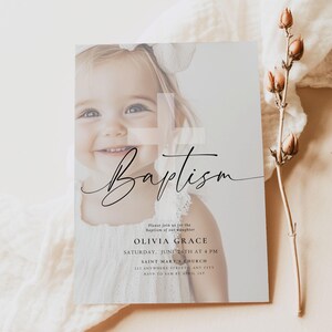May include: Baptism invitation featuring a smiling child with a white bow. The invitation includes the name Olivia Grace, date, time, and location. The design is elegant with a soft, neutral color palette and delicate script font.