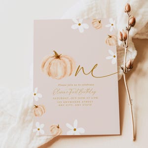 Pu&ograve; includere: Un biglietto d'invito rosa pallido con una zucca ad acquerello e dettagli floreali. Il testo "one" &egrave; in oro, con i dettagli della festa per il primo compleanno di Olivia. Il design include fiori bianchi e piccole zucche.