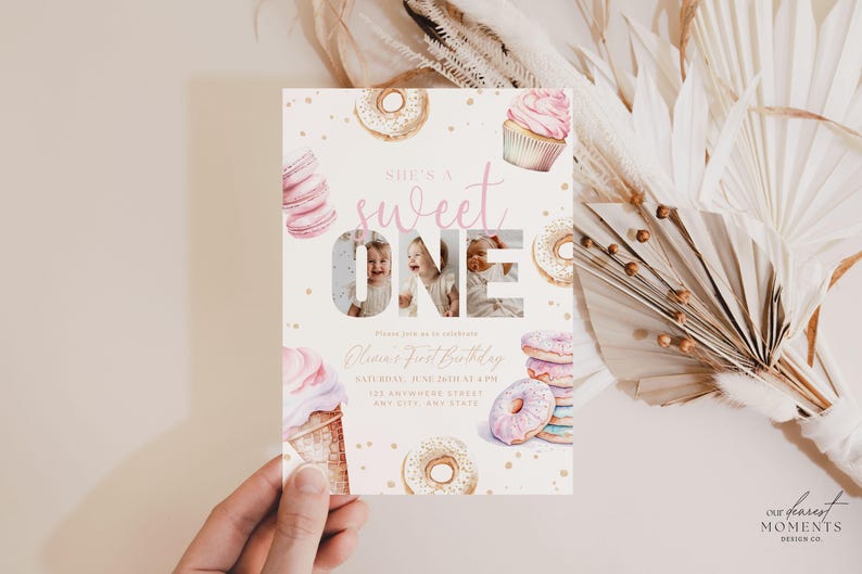 May include: A pink and gold first birthday invitation with a donut and cupcake theme. The invitation features a photo of a child in the number "one" and the text "She's a sweet one".