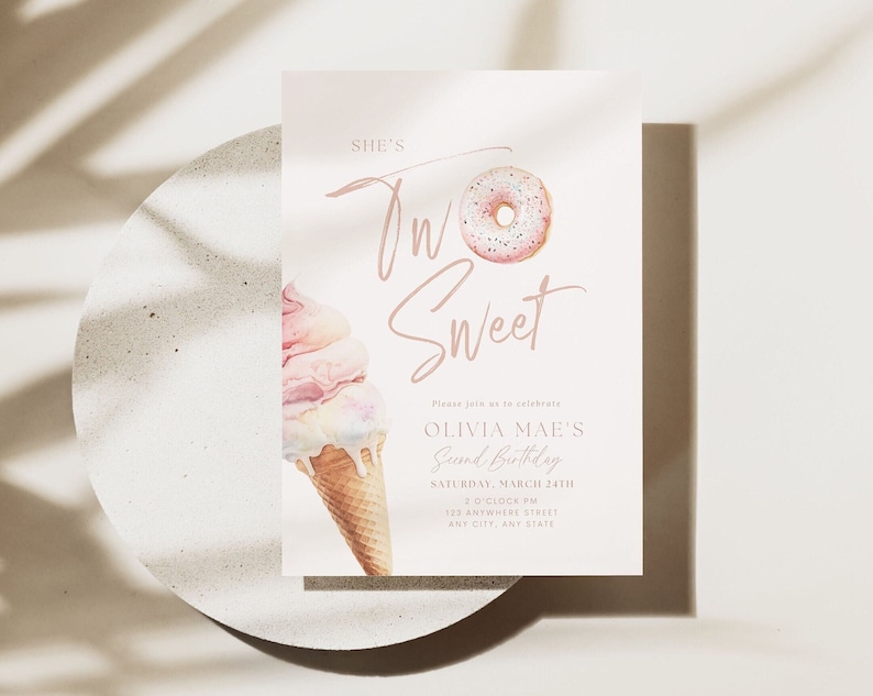 May include: A light pink invitation card with the text "She's Two Sweet" and details for Olivia Mae's second birthday. The design includes watercolor illustrations of a donut and an ice cream cone. The card is on a light gray surface.