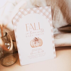 Pode incluir: Um convite para um ch&aacute; de beb&ecirc; em gingham rosa e branco com uma ilustra&ccedil;&atilde;o em aquarela de uma ab&oacute;bora com um la&ccedil;o. O texto diz "Fall in love with Baby Smith" e inclui a data e hora do ch&aacute; de beb&ecirc;.