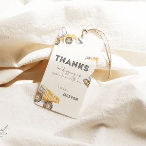 May include: A white thank you tag with a yellow construction truck design. The tag says "Thanks for digging up some fun with me. Love, Oliver."