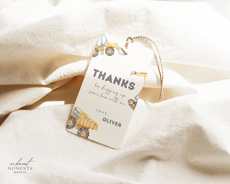 May include: A white thank you tag with a yellow construction truck design. The tag says "Thanks for digging up some fun with me. Love, Oliver."