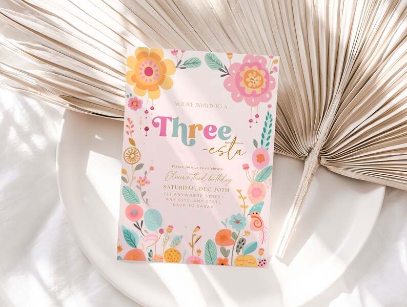 May include: A pink and white invitation card with colorful floral illustrations and the text "YOU'RE INVITED TO A Three-esta Olivia's third birthday SATURDAY, DEC 20TH 123 ANYWHERE STREET ANY CITY, ANY STATE RSVP TO SARAH"