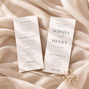 Op de afbeelding: Twee rechthoekige witte trouwprogramma-kaarten met zwarte schreef- en scripttekst. De rechterkaart toont de namen Sophia en Henry, de datum 02.09.20XX en ceremoniedetails. De linkerkaart vermeldt de bruiloftsgasten en de receptie-informatie.
