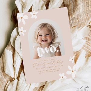May include: A pink and white birthday invitation with a photo of a young girl smiling. The invitation says "two." and "Olivia's Second Birthday". The invitation also includes the date, time, and location of the party.