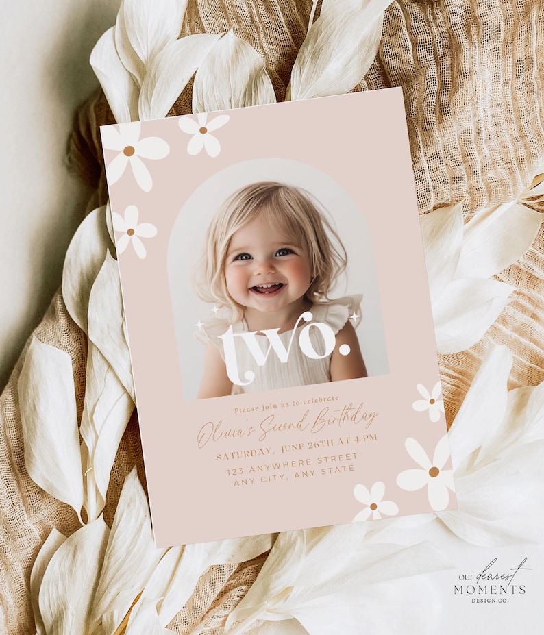 May include: A pink and white birthday invitation with a photo of a young girl smiling. The invitation says "two." and "Olivia's Second Birthday". The invitation also includes the date, time, and location of the party.