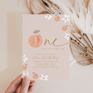 Może przedstawiać: R&oacute;żowe zaproszenie urodzinowe z akwarelowym motywem brzoskwini i kwiat&oacute;w. Na zaproszeniu widnieje napis "One Sweet Peach" i szczeg&oacute;ły wydarzenia. Projekt przedstawia brzoskwinię i białe kwiaty.