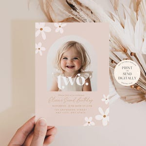 May include: A pink and white printable birthday invitation with a photo of a young girl. The invitation says "two." and includes the text "Please join us as we celebrate [Name]'s Second Birthday. Birthday: June 30th at 4 PM. 123 Anywhere Street, Any City, and State."