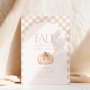 Pode incluir: Um convite para um ch&aacute; de beb&ecirc; com tema de outono. O convite apresenta uma ab&oacute;bora com um la&ccedil;o xadrez e o texto "Fall in love with Baby Smith". O convite &eacute; decorado com um padr&atilde;o xadrez.