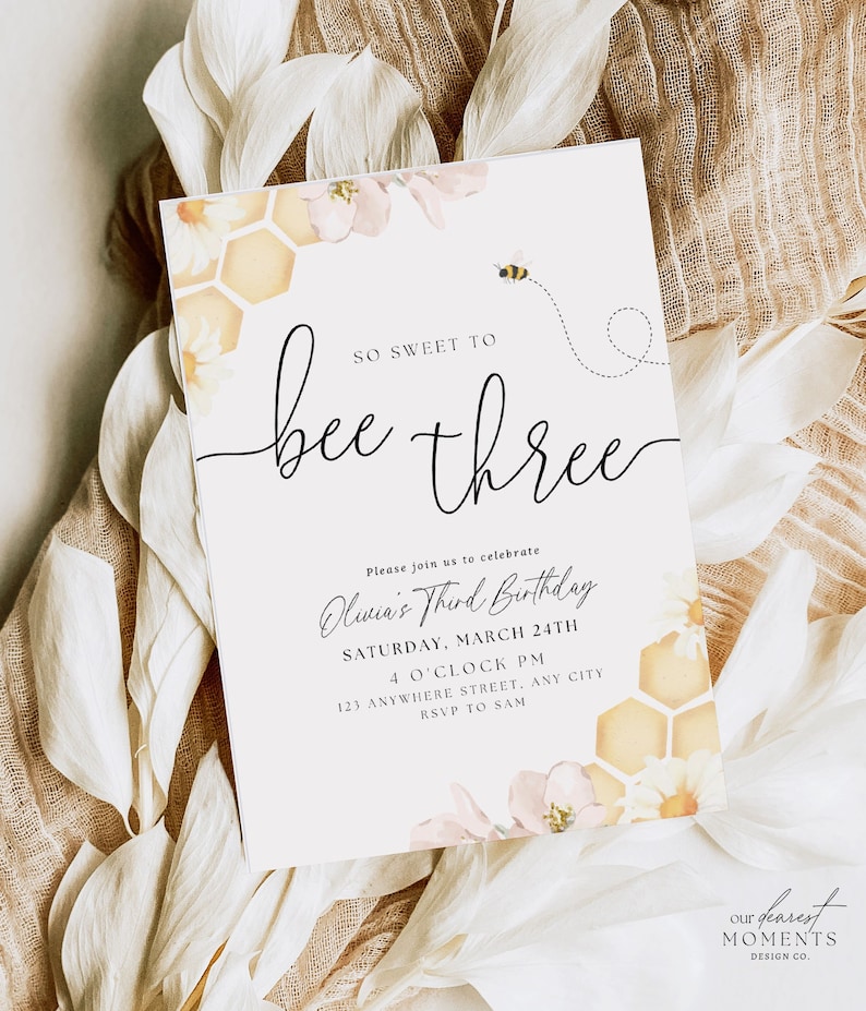 May include: A white invitation card featuring a bee and honeycomb design. The text reads "So sweet to bee three" and includes details for Oliwia's third birthday party. The invitation is decorated with pink and yellow flowers.