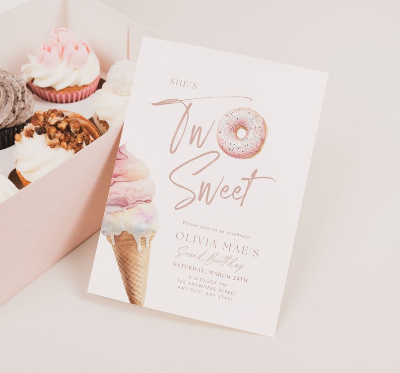 May include: A pale pink birthday invitation with the words "She's Two Sweet" and a donut and ice cream cone illustration. The invitation is for Olivia Mae's second birthday, with the date, time, and address. A box of cupcakes is visible in the background.