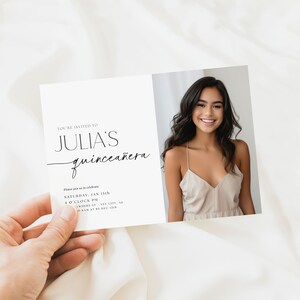 K&ouml;nnte beinhalten: Eine Quincea&ntilde;era-Einladung mit einem Foto einer l&auml;chelnden jungen Frau in einem beigen Kleid. Der Einladungstext lautet "Julia's Quincea&ntilde;era" in eleganter Schrift, mit Veranstaltungsdetails darunter. Das Design ist minimalistisch und modern.