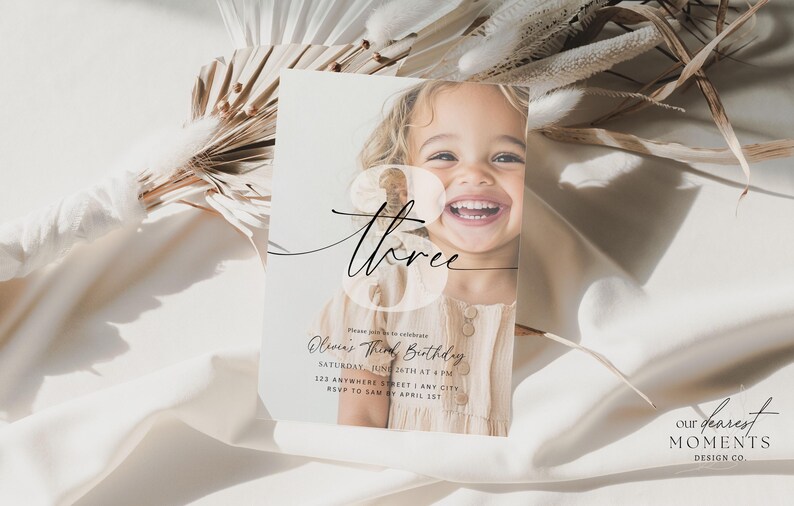 May include: A white invitation card with a photo of a young girl smiling. The card has a black and white design with the text "three" and "Chloe's Third Birthday".