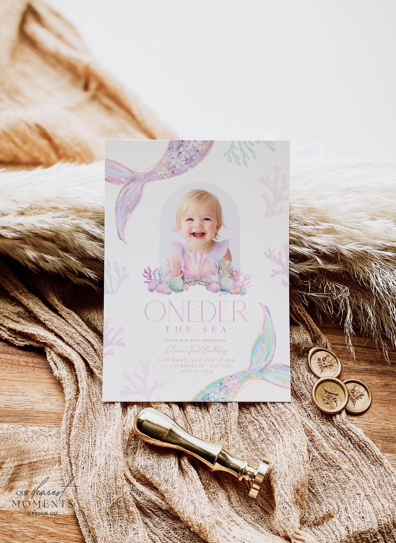 May include: A pink and blue mermaid-themed first birthday party invitation with a photo of a baby girl. The invitation says "One-der the Sea" and includes the date and time of the party.