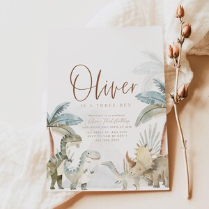 K&ouml;nnte beinhalten: Eine hellblaue und braune Einladungskarte mit Dinosaurier-Motiv. Die Karte lautet "Oliver is a Three Rex" und enth&auml;lt Details f&uuml;r eine Geburtstagsfeier. Der Text lautet "Please join us to celebrate Oliver's Third Birthday, Saturday, Dec 20th at 4pm, 123 Apple St, Any City, RSVP to Sam by Dec 1, 555-555-5555". Am unteren Rand der Karte steht "our dearest MOMENTS DESIGN CO."